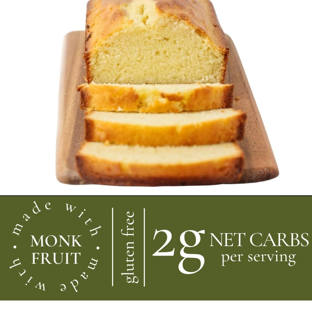 Loaf of bread with slices on a wooden board, labeled as gluten-free and made with monk fruit sweetener.